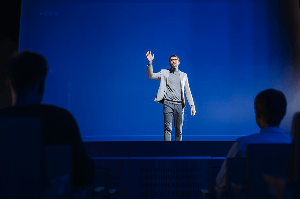 Man waving onstage