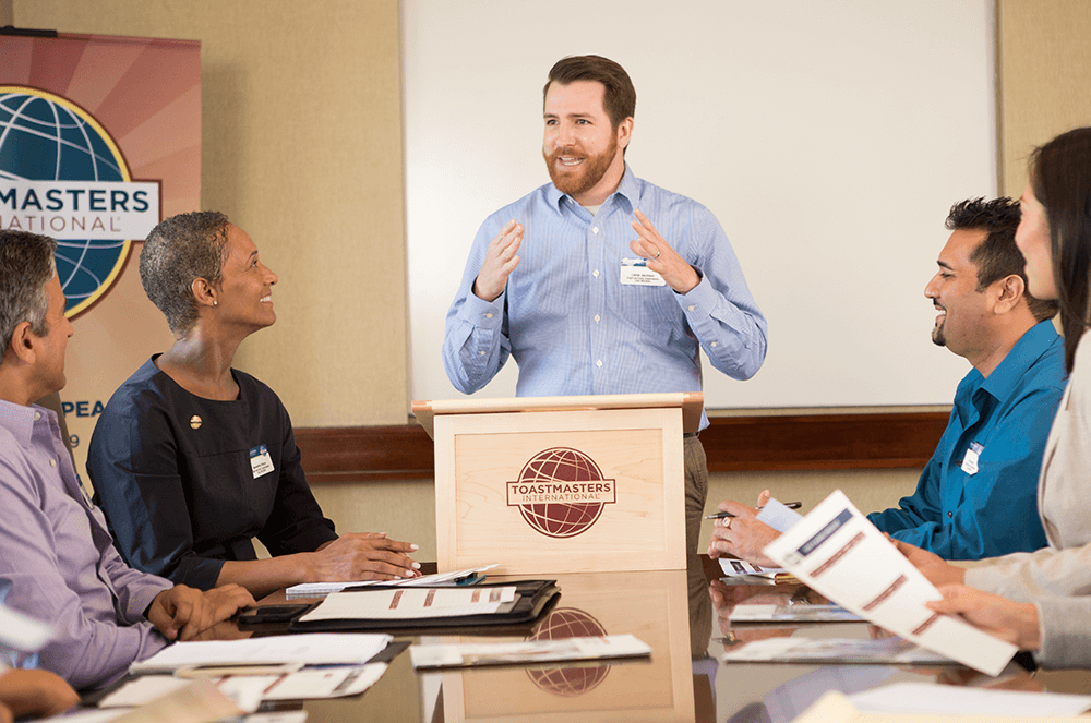 Man in blue shirt giving speech at lectern