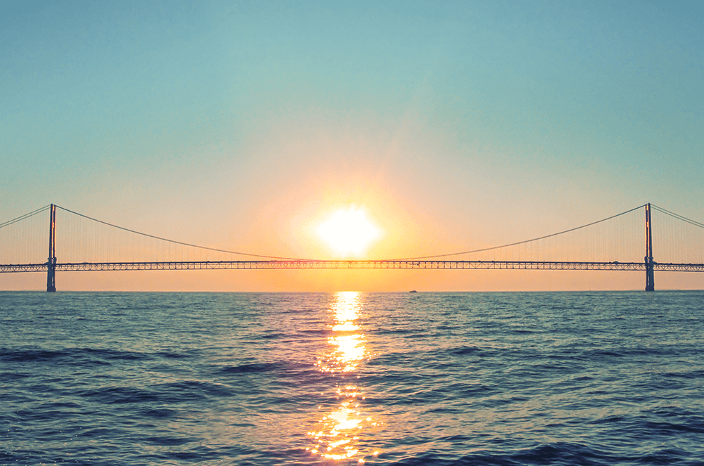Large bridge over water with sunsetting in background