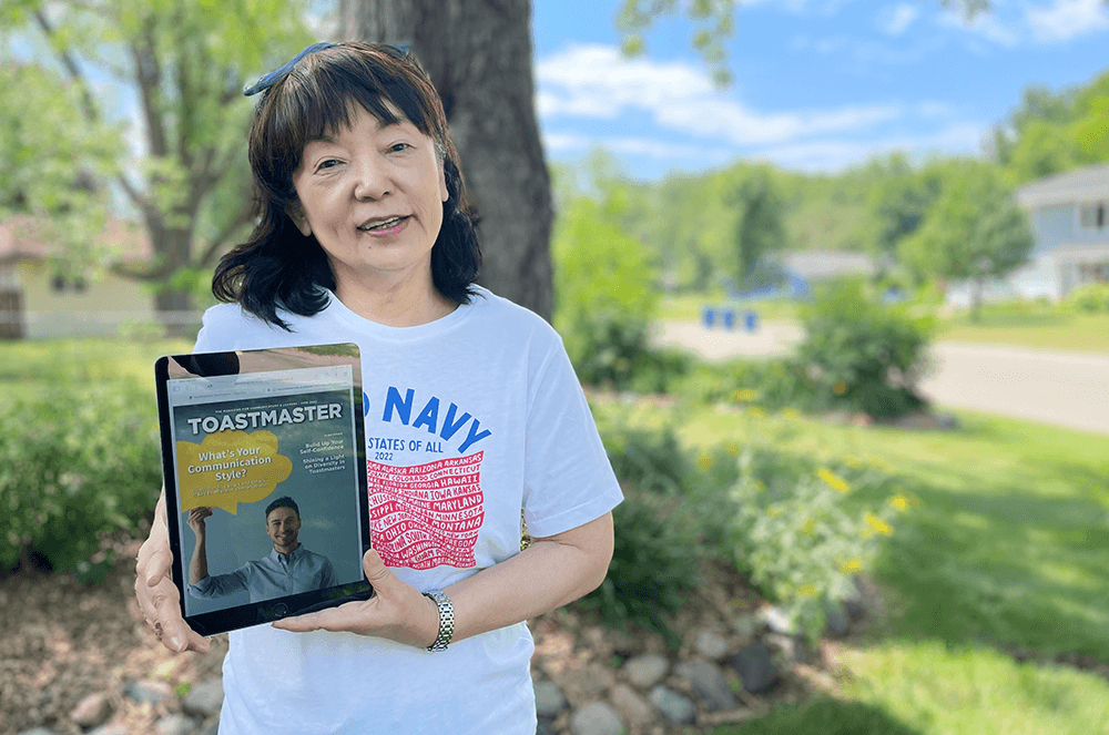 Woman holding iPad with Toastmaster magazine