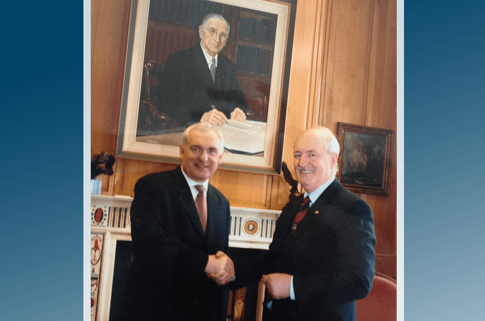 Two men shaking hands and smiling. Photo credit: Kevin Forde