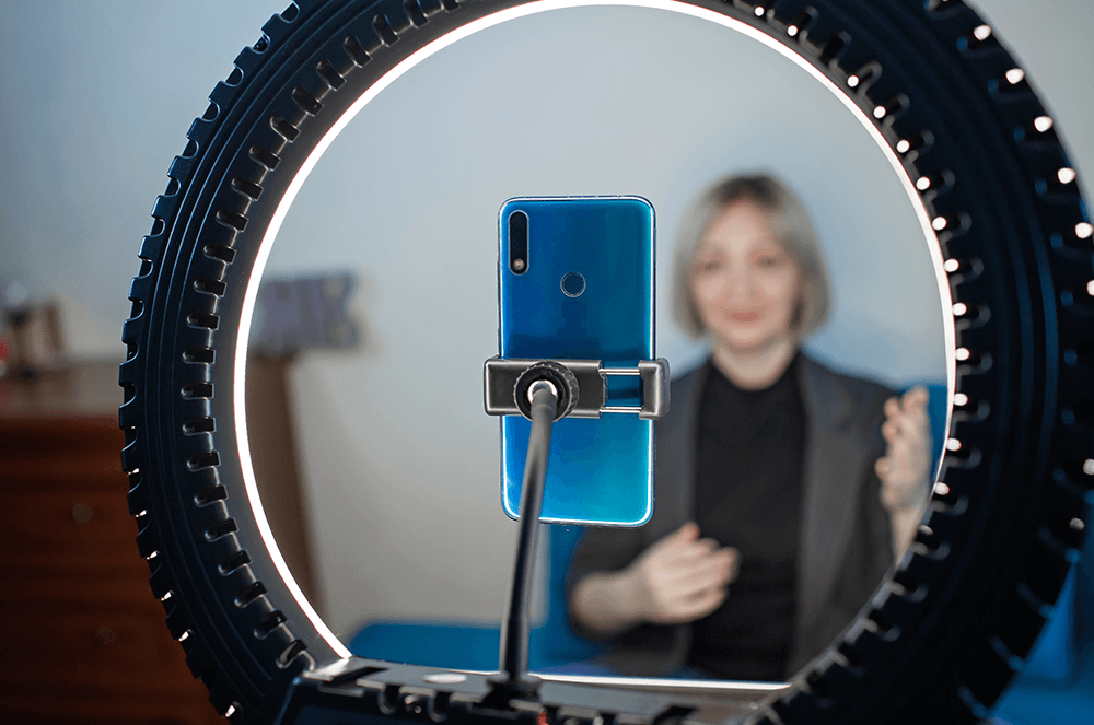 Woman recording speech with phone and ring light