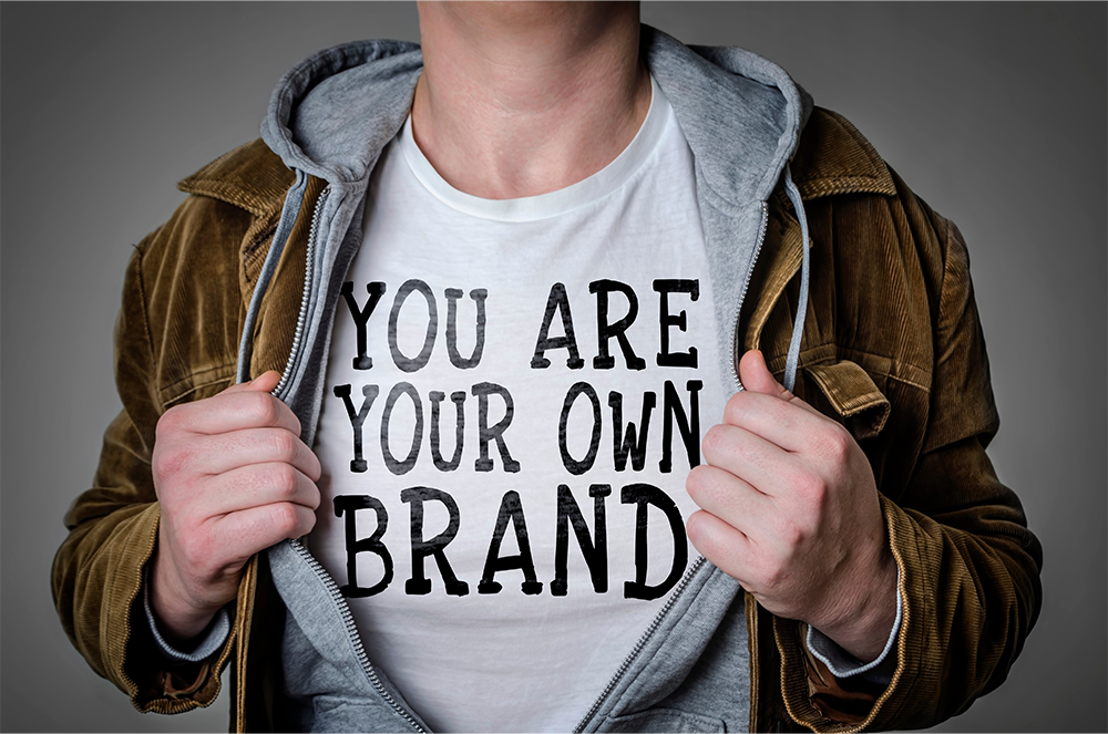 Man wearing white t-shirt that says you are your own brand