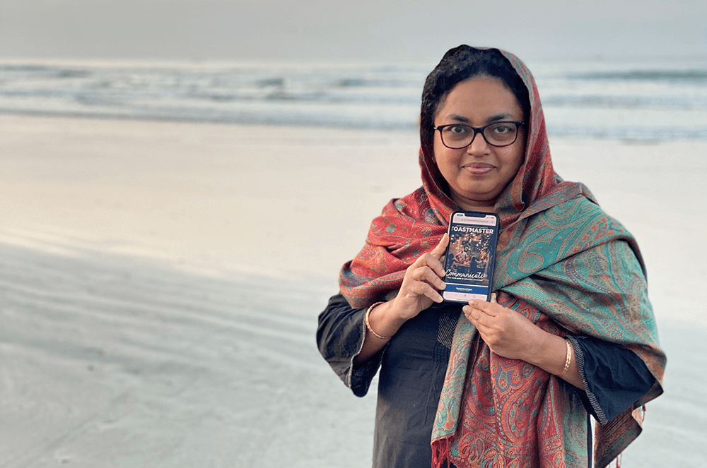 Woman standing on beach holding iPhone