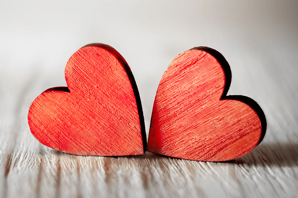 Two red hearts on wood background