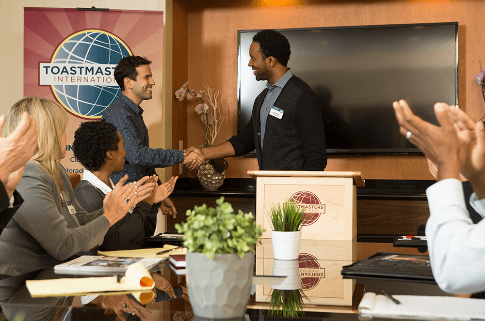 Two men shaking hands at Toastmasters meeting