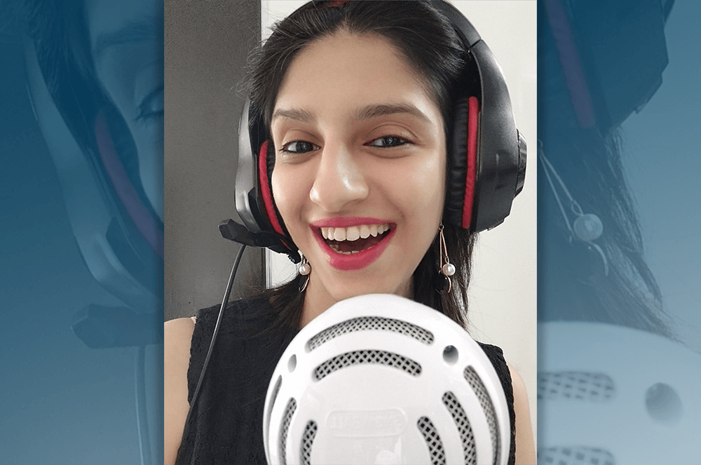 Woman wearing headphones standing in front of microphone while smiling  