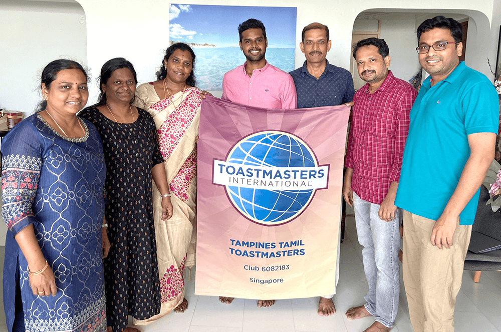 Group of people posing with Toastmasters banner 