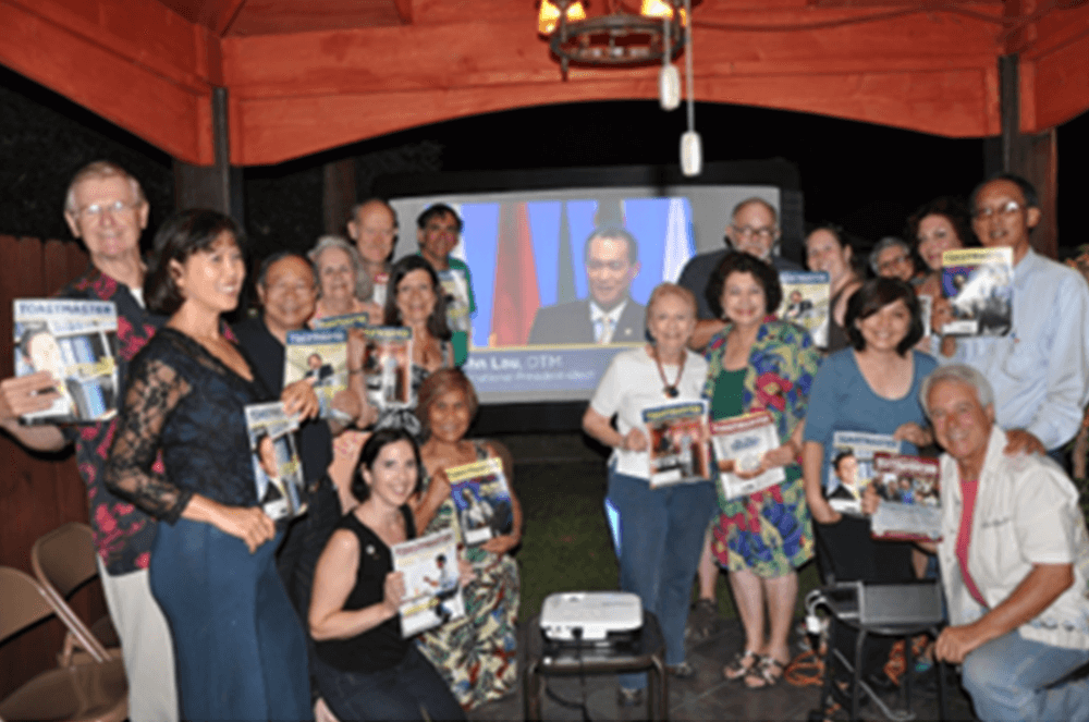 Toastmaster Carl Walsh, (right, front), along with members of the A.C.T.S. club in Pasadena, California, gather in his back yard to watch the 2012 World Championship of Public Speaking finals streamed live from the Toastmasters International Convention in Orlando, Florida.