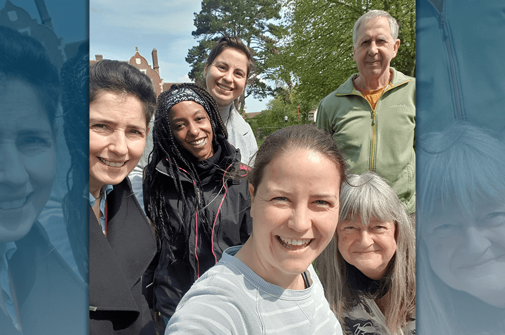 Six people smiling for group selfie