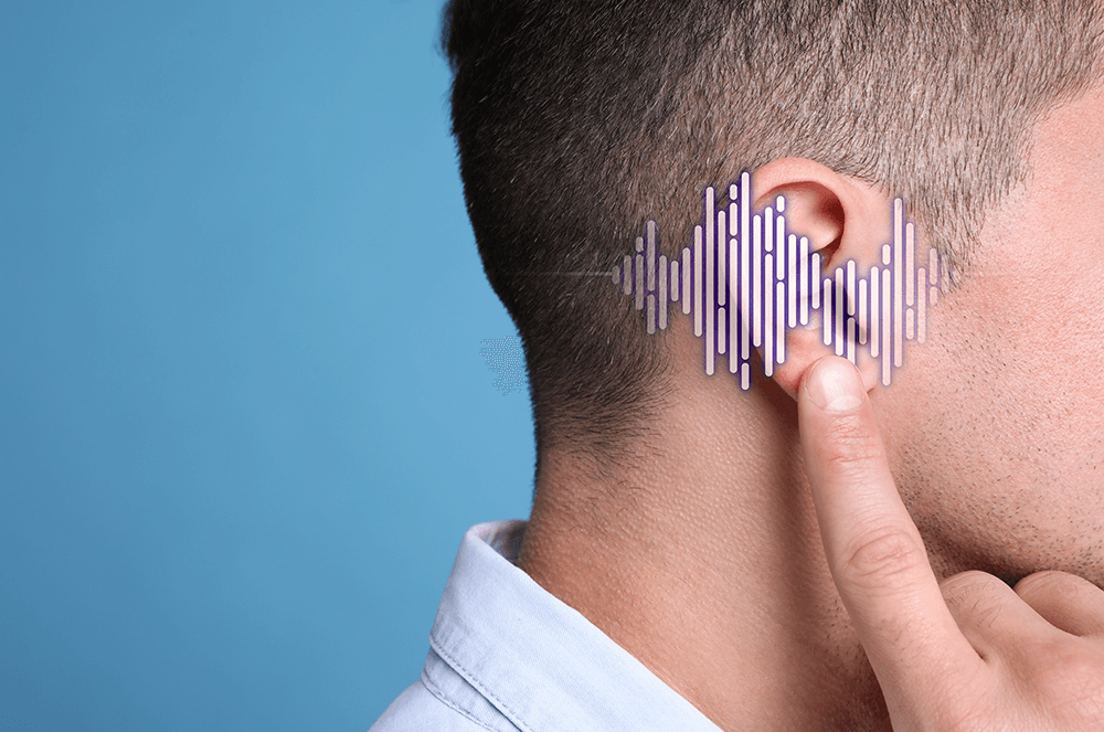 Man holding up finger to ear with sound waves going across