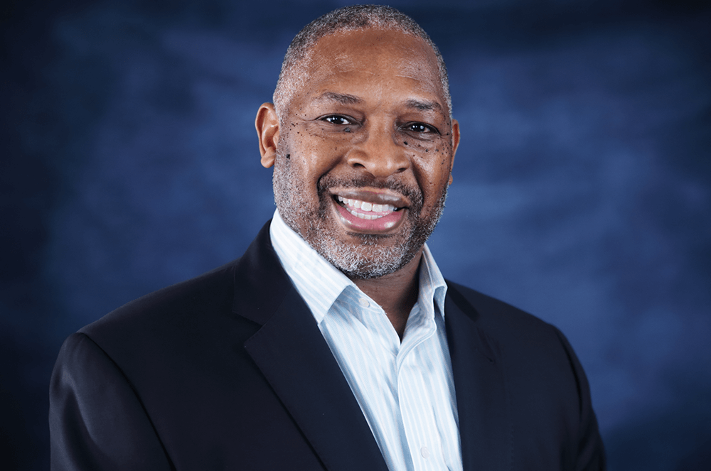 Man smiling in white shirt and suit jacket