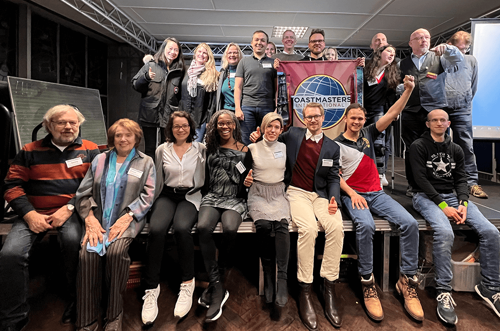 Group of people smiling and posing with banner