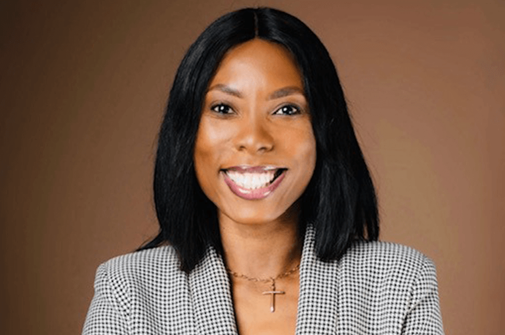 Woman in black and white suit jacket smiling