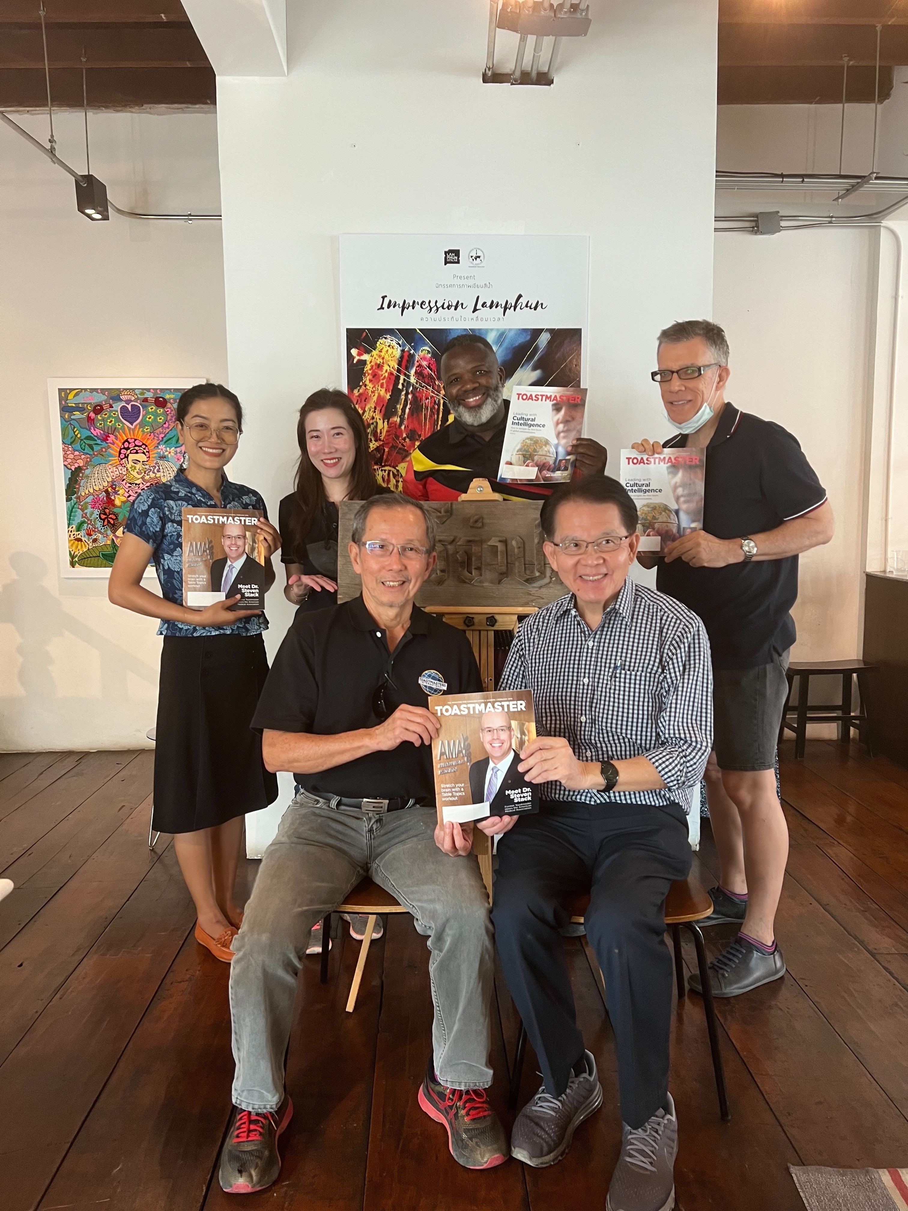 Five people posing while holding magazines