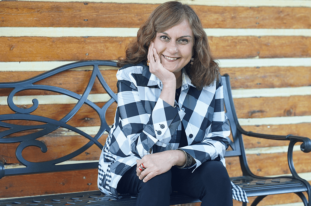 Woman sitting on bench resting head in hand wearing black and white checkered