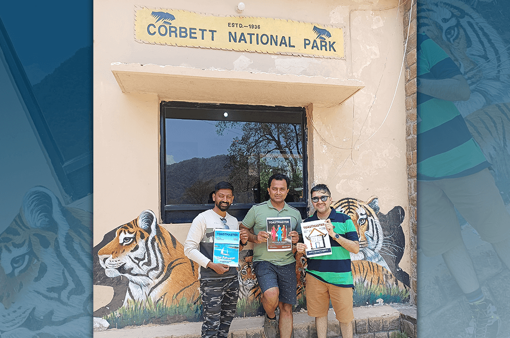 Three men holding up Toastmaster magazine at Tiger Reserve in Corbett National Park