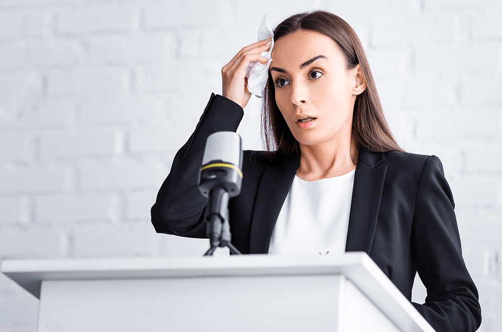 Woman looking nervous at lectern with microphone
