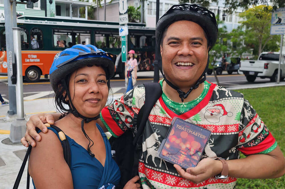 Man and woman posing outdoors in bicycle helmets in Key West