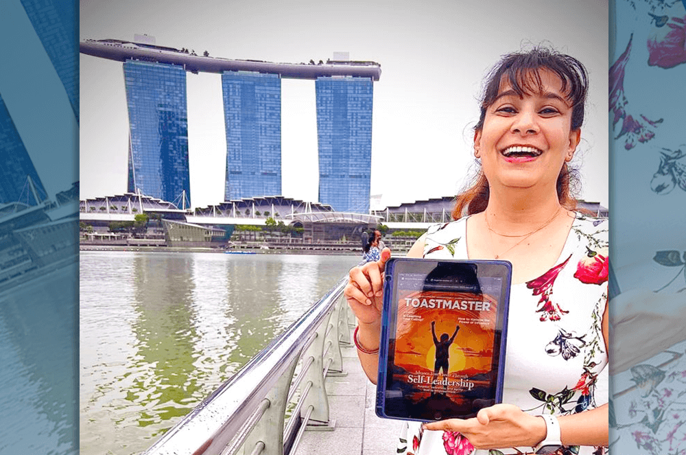 Woman holding digital edition of the Toastmaster magazine in Singapore
