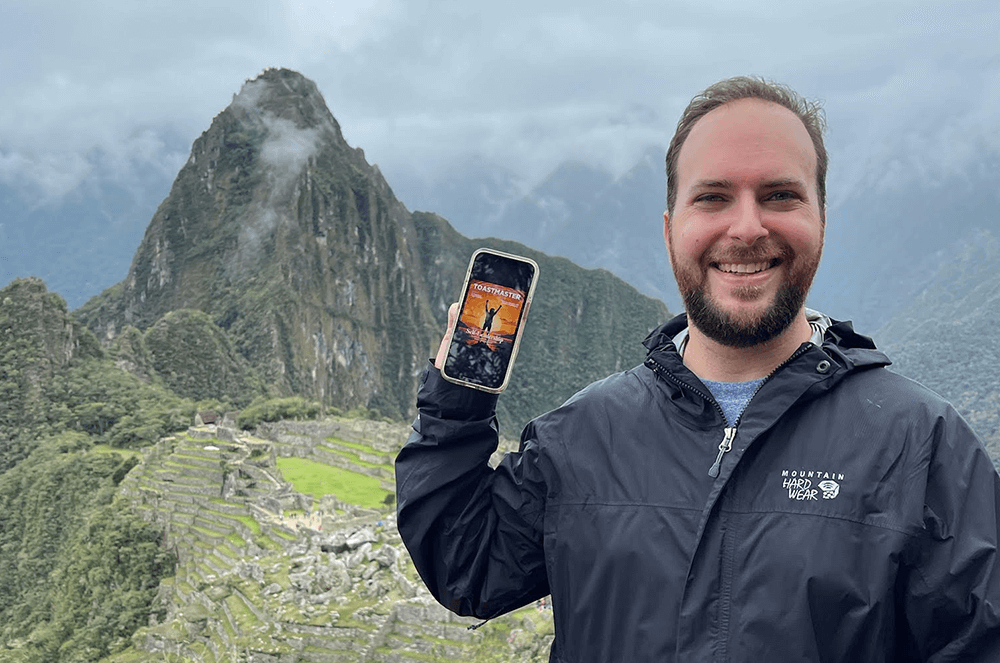 Man holding iPhone near Machu Picchu