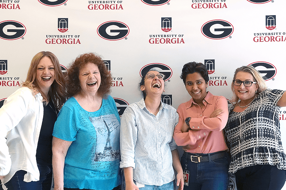 Five women laughing and smiling