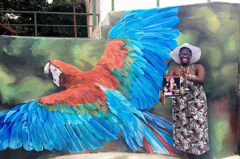 Jessica Parks, CC, from Athens, Georgia, poses in front of a parrot mural in Manuel Antonio, Costa Rica.