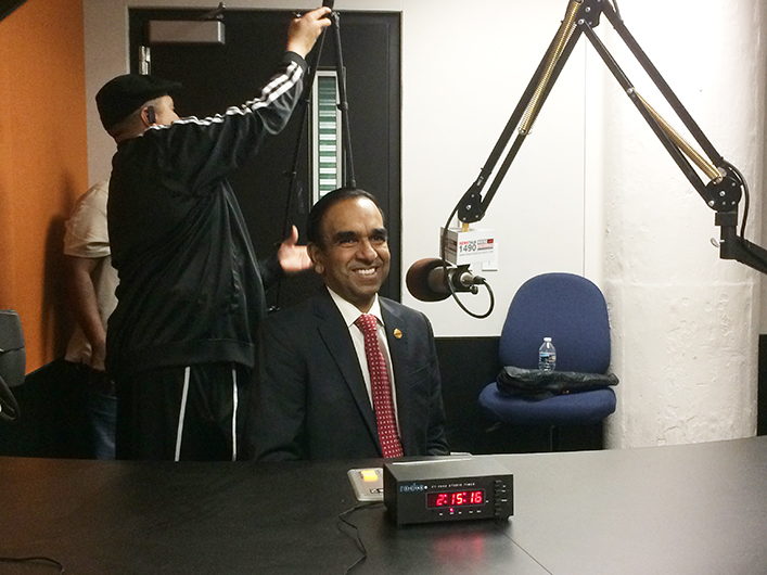 International President Balraj Arunasalam, prepares for a broadcast for iHeartRadio.