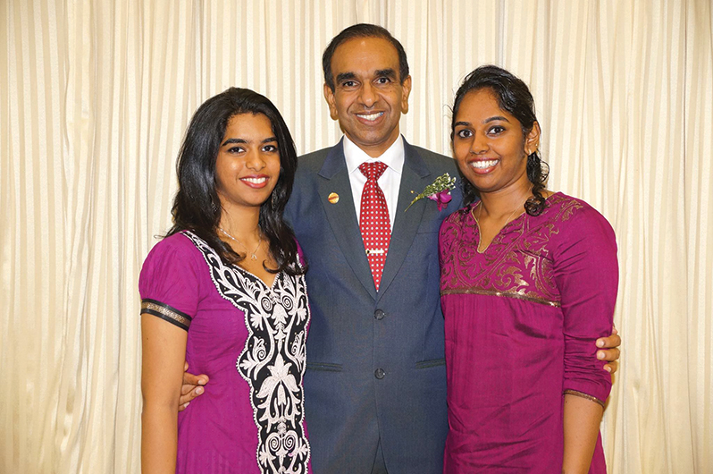 The proud father stands with daughters Mahishaa (left) and Avisha (right).