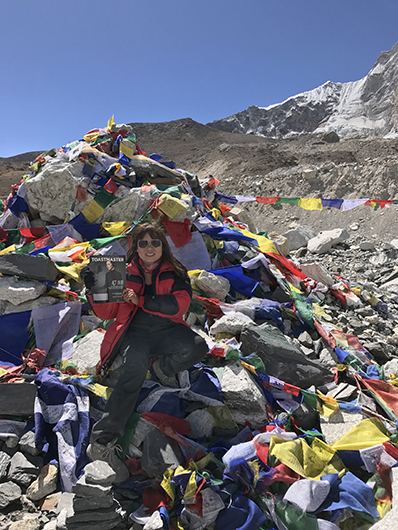 Tarn Wallace, CC, from Melbourne, Australia, stops to pose with her magazine during her climb to Mount Everest Base Camp in Nepal.