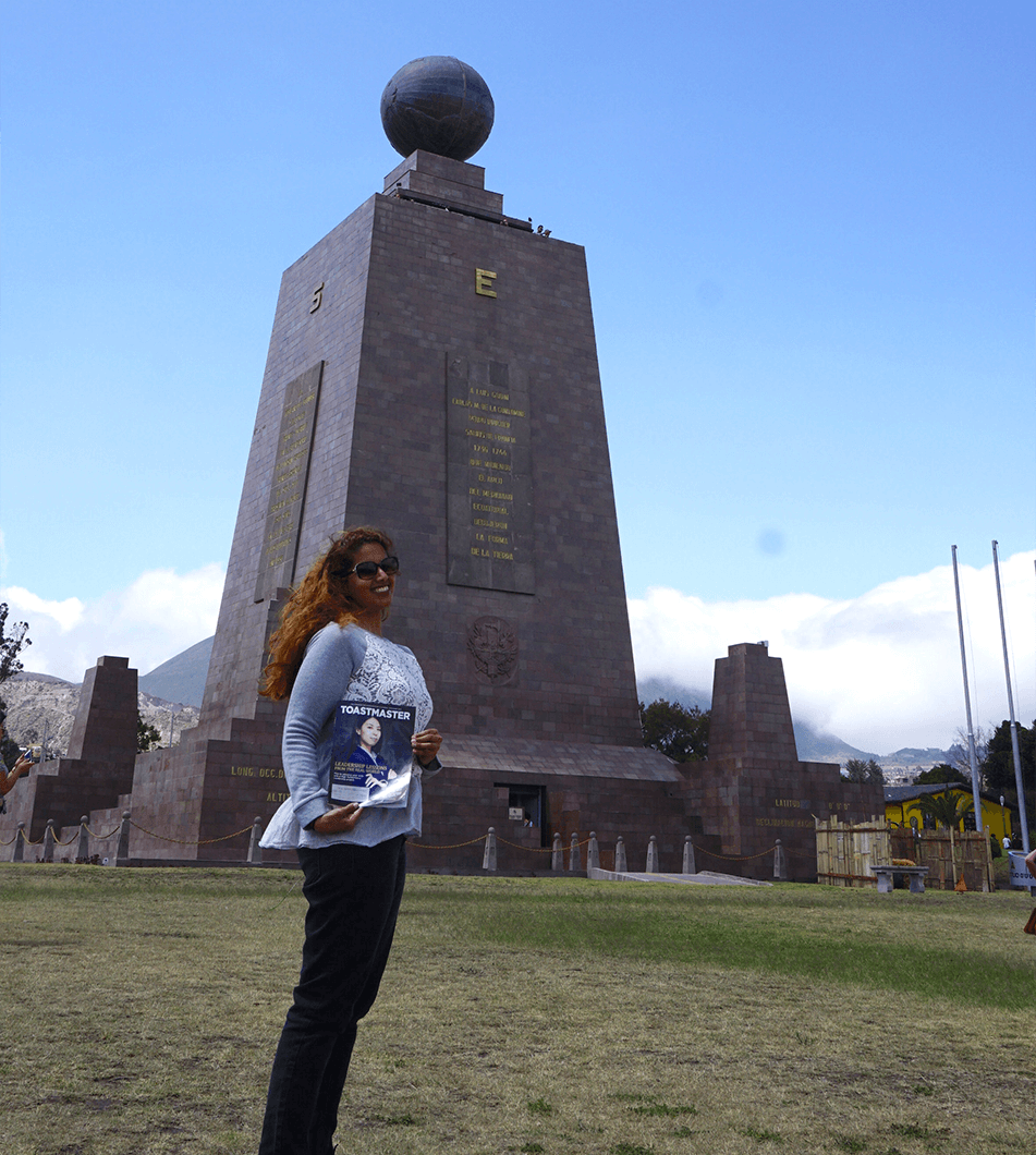 Fay al-Najadah, ACB, CL, of Kuwait City, Kuwait, stands by the towering "Monument to the Equator," in Pichincha, Ecuador, Central America.