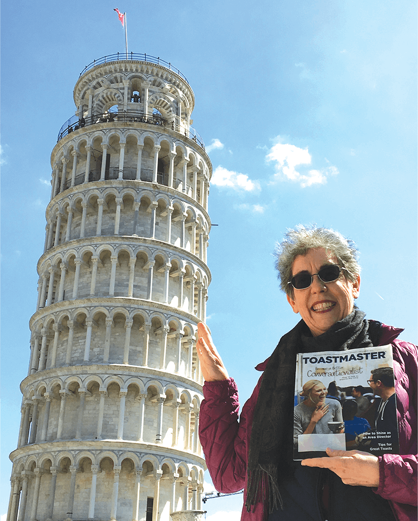 Marylee Mims, DTM, of Colleyville, Texas, playfully poses by the Leaning Tower of Pisa in Italy.