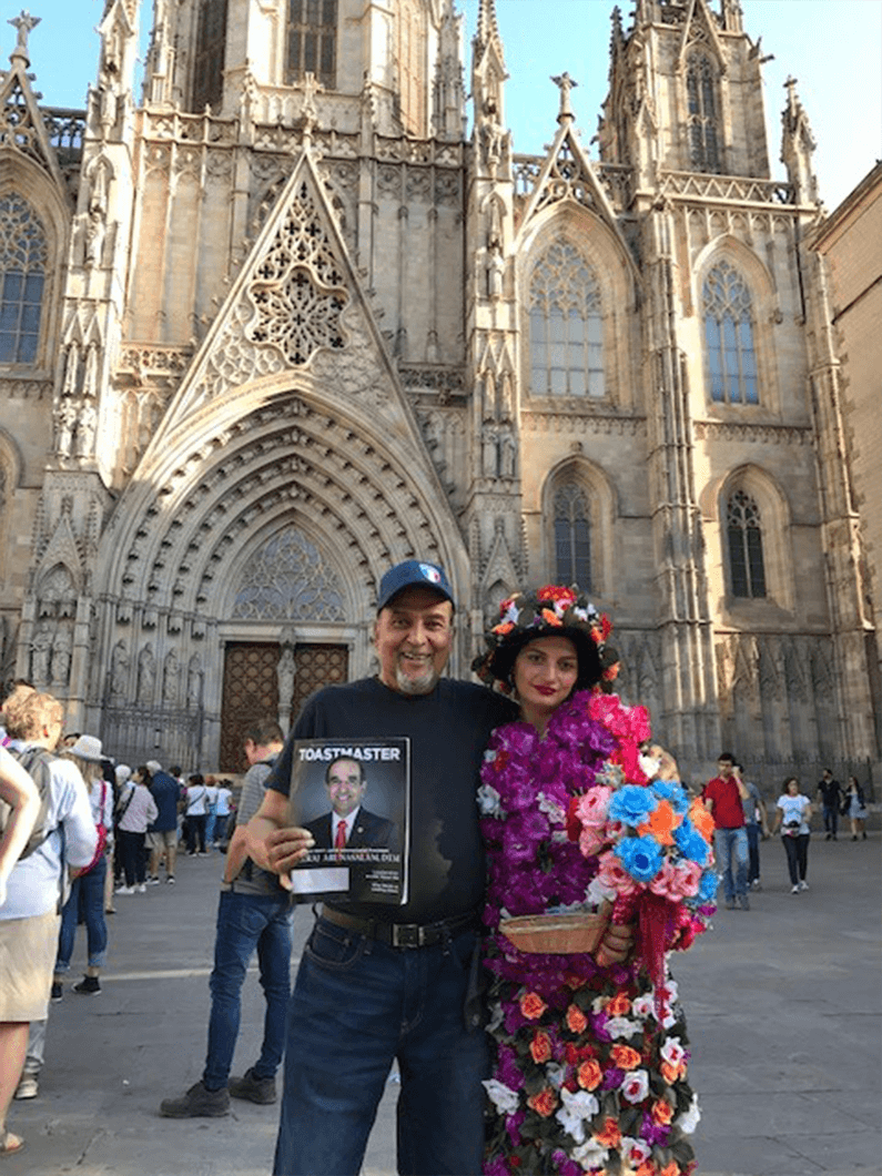 Azad Hamid, ACG, ALB, of Toronto, Canada, with a local flower vendor outside the Cathedral of the Holy Cross and Saint Eulalia, in Barcelona, Spain.