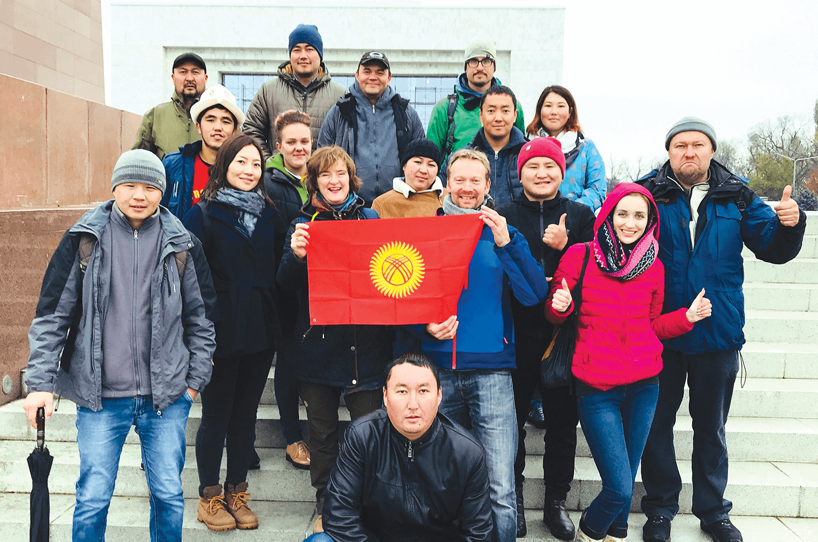 Instructors from the tour-guide training company EastguidesWest with a group of tourism students holding the flag of Kyrgyzstan in the capital city of Bishkek. Photo by EastguidesWest