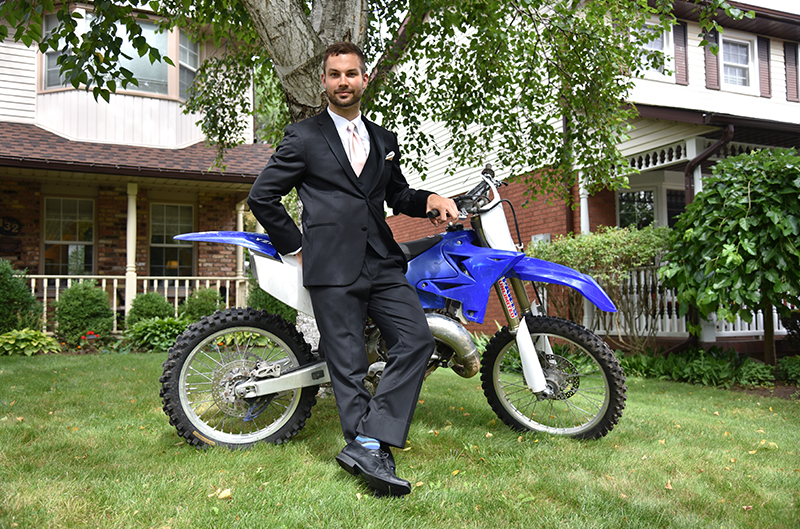 Myles, who grew up racing motocross in the U.S. and Canada, poses with his bike.
