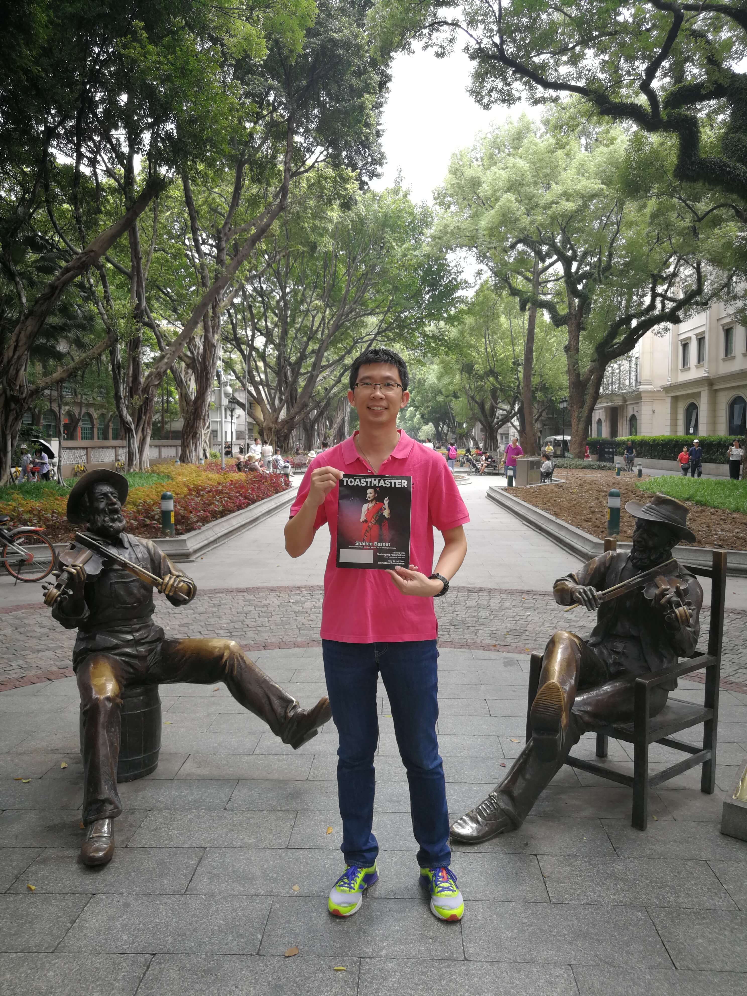 Goh Chee Yong of Petaling Jaya, Malaysia, stands between two violinist statues in Shamian Park, a sandbank island in Guangzhou, China. 