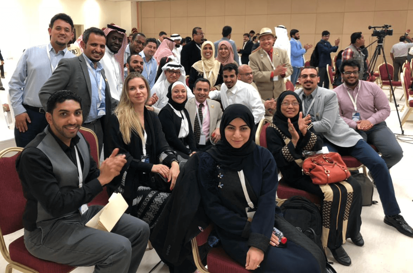 Bilquis Ahmed (pictured in back wearing yellow hijab), poses with her fellow Toastmasters in Saudi Arabia.