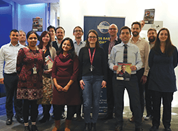 Group of Toastmasters members standing with banner