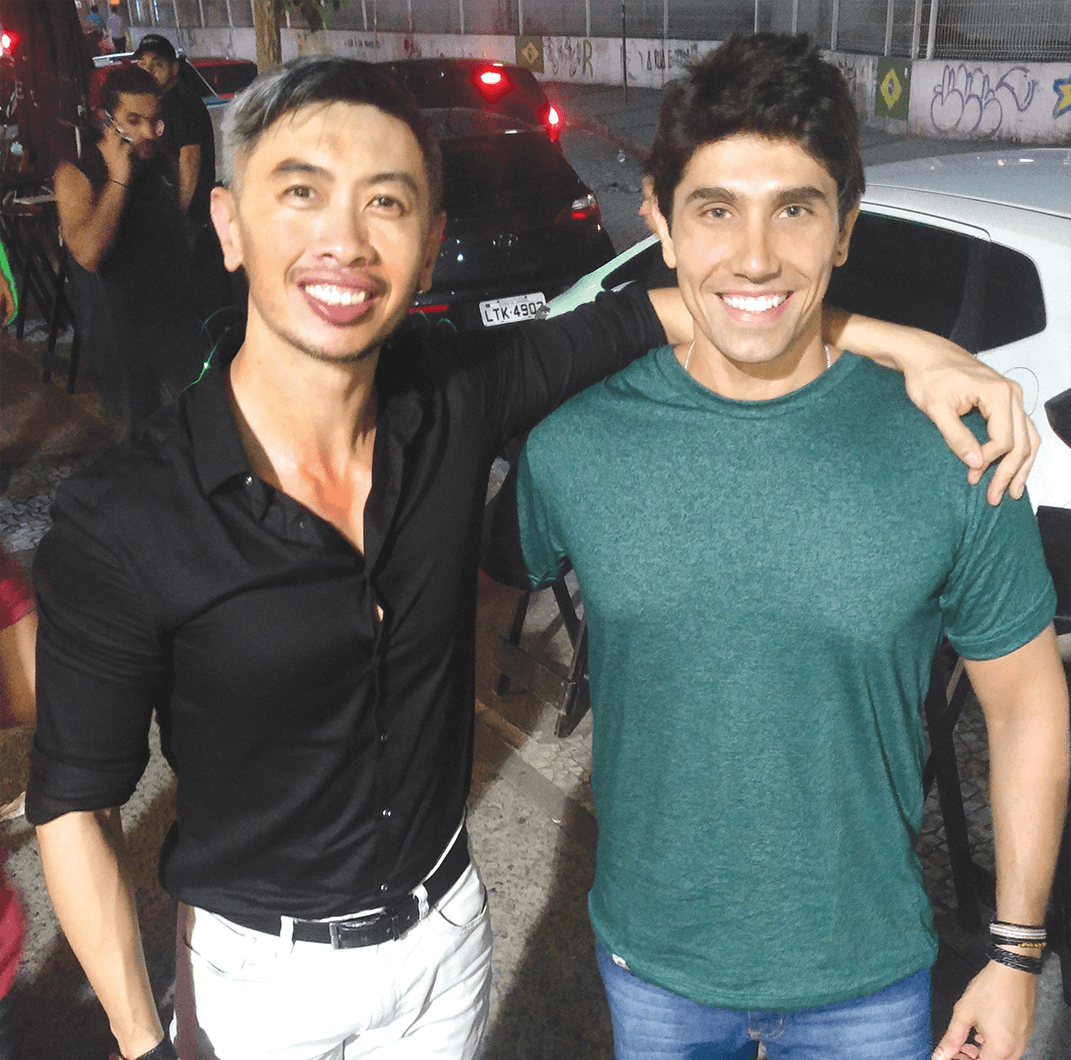 Man in black shirt poses with man in green shirt
