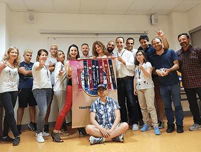 Group of Toastmasters members in Spain pose with banner
