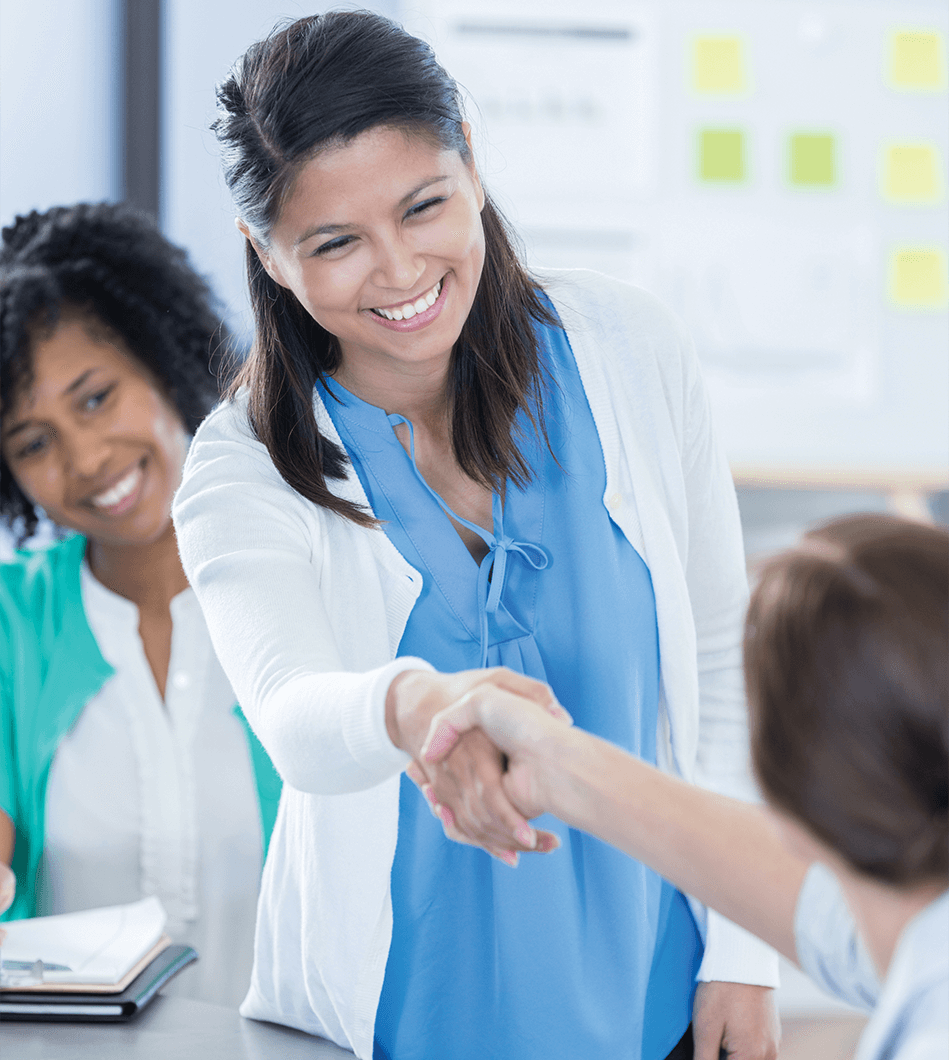 Woman in blue shirt shaking hands with someone