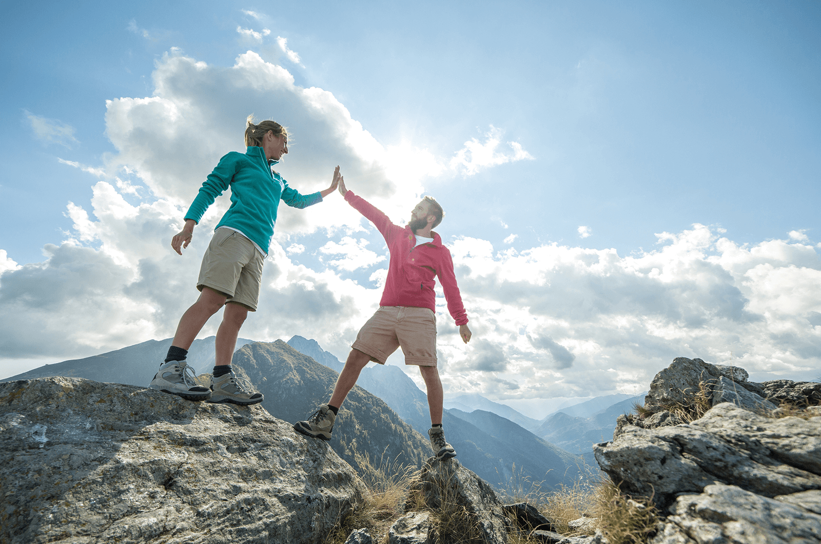 Man and woman high-five on top of mountain