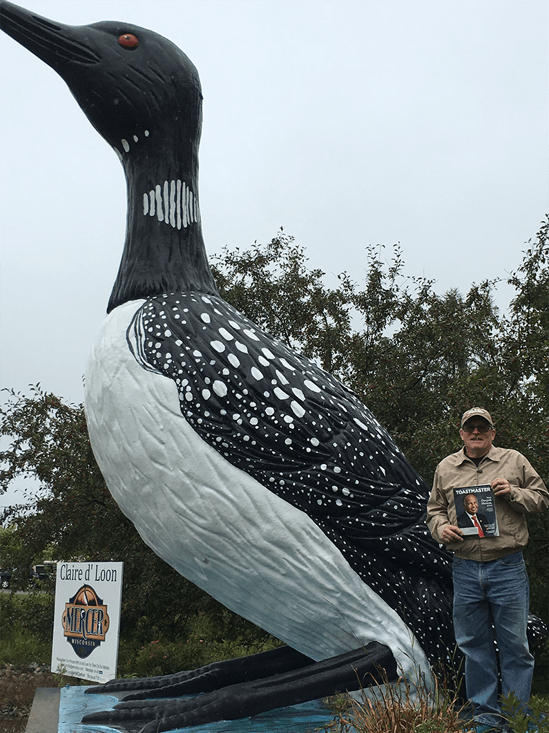 Andrew Safranski of Neenah, Wisconsin, poses with the World’s Largest Talking Loon in Mercer, Wisconsin. The statue stands 16 feet tall in front of the Mercer Chamber of Commerce building, where is has been since 1981. 