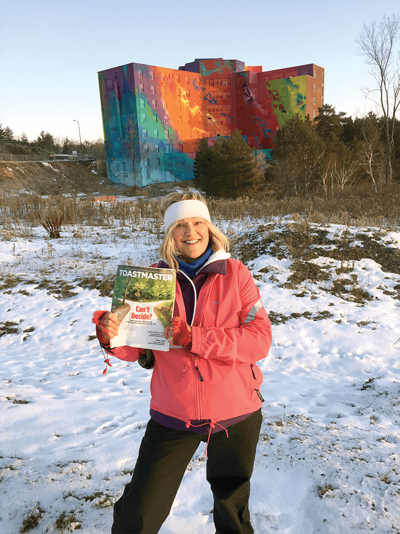 Sandi Emdin, DTM, of Sudbury, Ontario, Canada, poses in front of an old hospital in Sudbury. It was painted last year and is now the largest mural in Canada. 