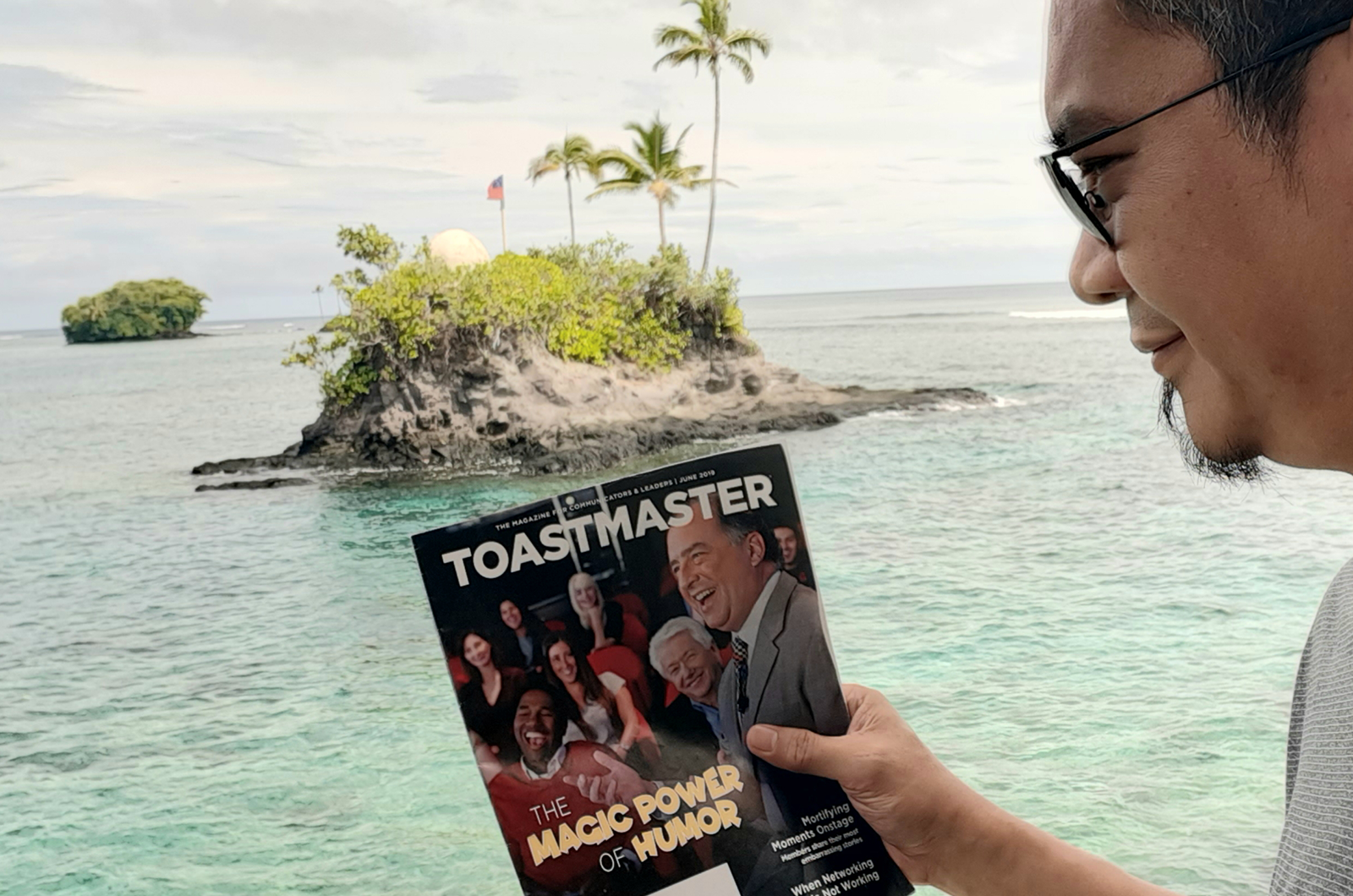 Anthony Foronda of Quezon City, Philippines, reads his Toastmaster at the beachfront after enjoying lunch in Aufaga, Upolu, Samoa. 