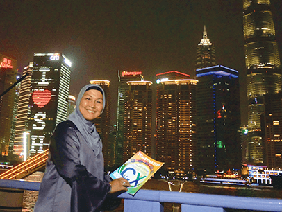 Julia Taha of Selangor, Malaysia, strolls along the Bund waterfront in Shanghai, China, and takes in the night scene, including the landmark Pearl TV Tower, lit in blue.