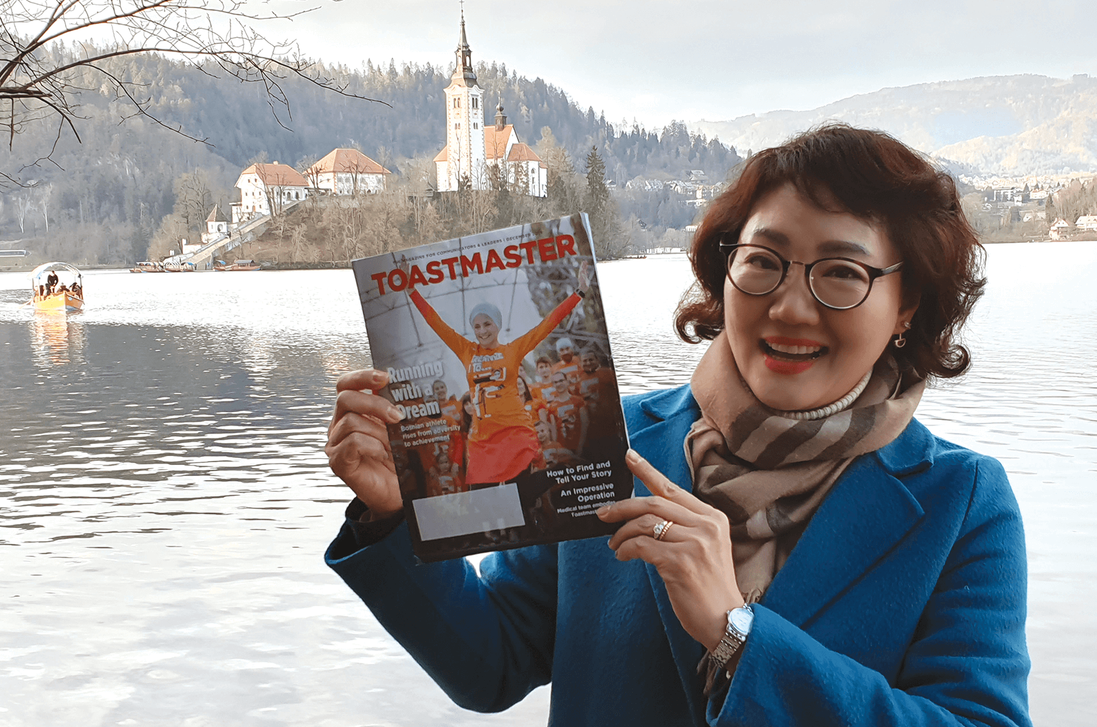 Seunghee Lisa Han, DTM, of Daegu, Korea, poses with her magazine at Lake Bled in northwestern Slovenia. 