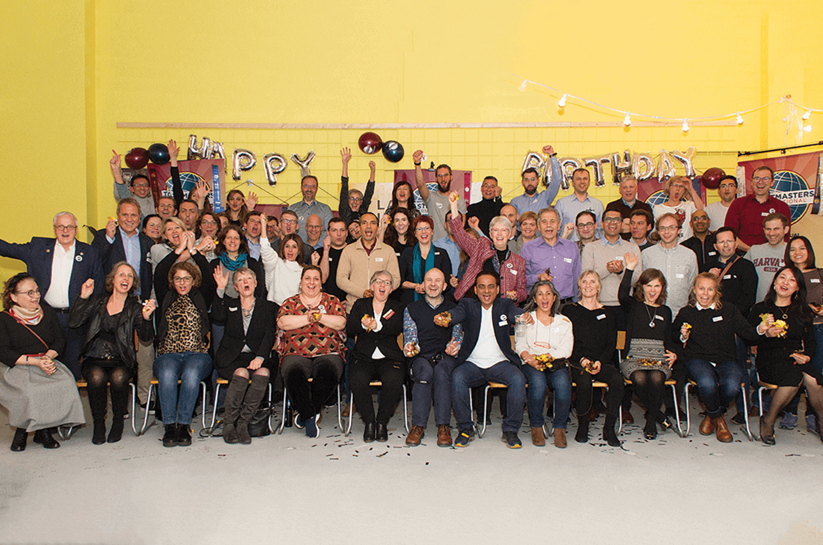 Large group of Toastmasters from Switzerland celebrating with hands in the air