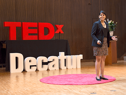 Anwesha Banerjee stands on red dot on TEDx stage