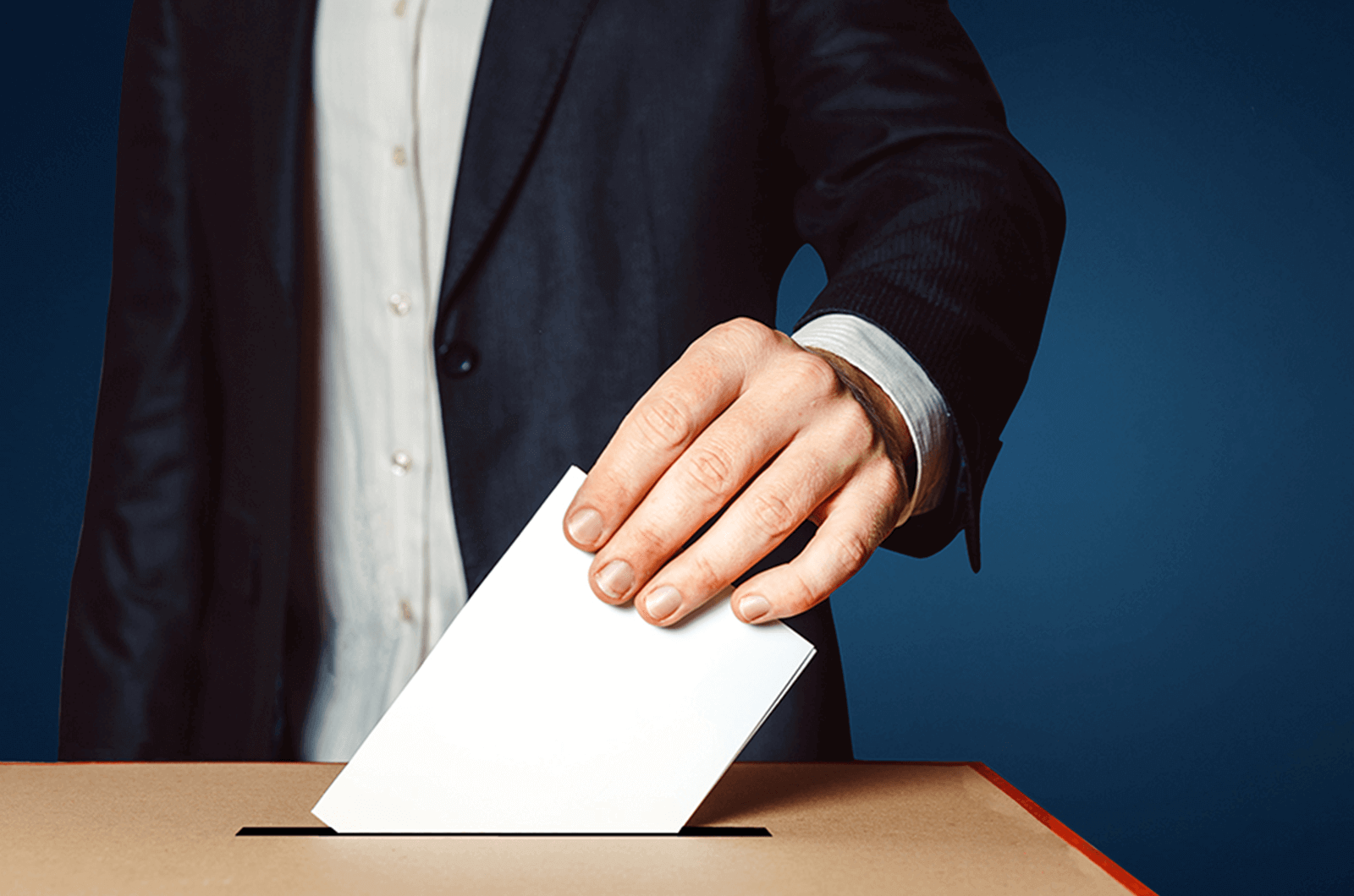 Man dropping piece of paper in ballot box